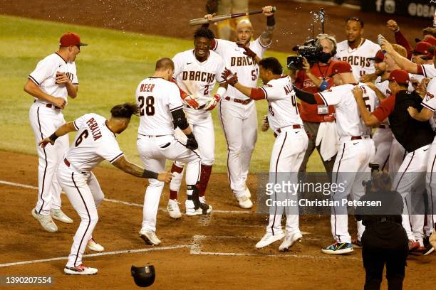 Seth Beer of the Arizona Diamondbacks is congratulated by teammates after hitting a walk-off three-run home run against the San Diego Padres during...