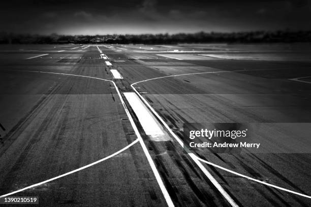airport runway taxiway tarmac closeup, dividing line, black and white - landing gear stock-fotos und bilder