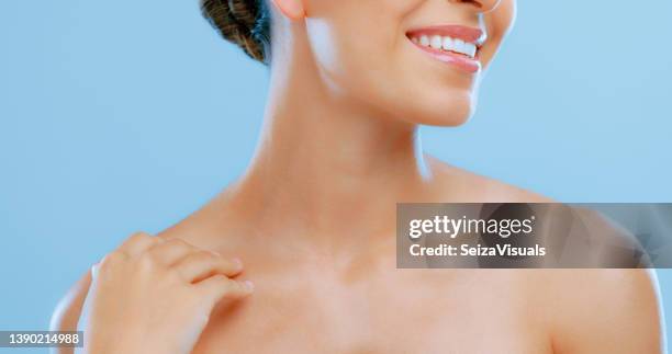 studio-aufnahme einer schönen jungen frau posiert vor einem blauen hintergrund - hals stock-fotos und bilder