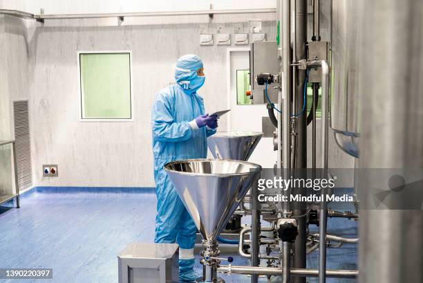 full length view of a researcher in an industrial laboratory facility - drug manufacturing stock pictures, royalty-free photos & images