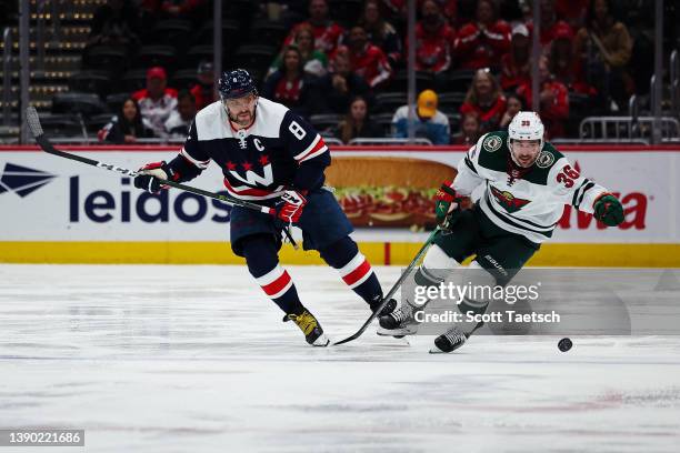 Alex Ovechkin of the Washington Capitals and Mats Zuccarello of the Minnesota Wild skate for the puck during the second period of the game at Capital...