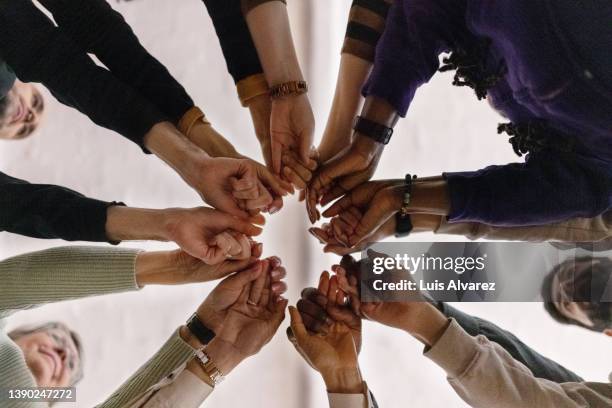 people with fist put together during support group session - uniforme imagens e fotografias de stock