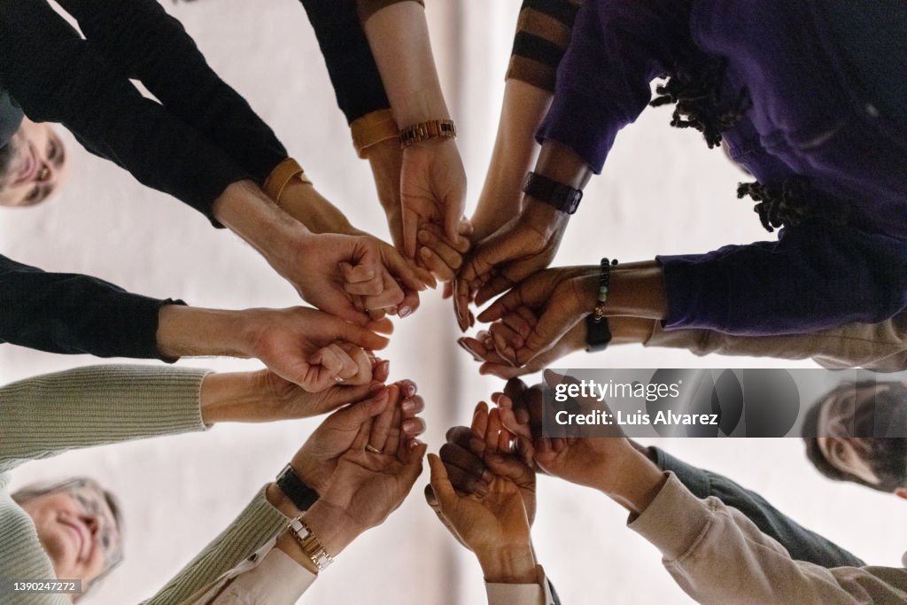People with fist put together during support group session