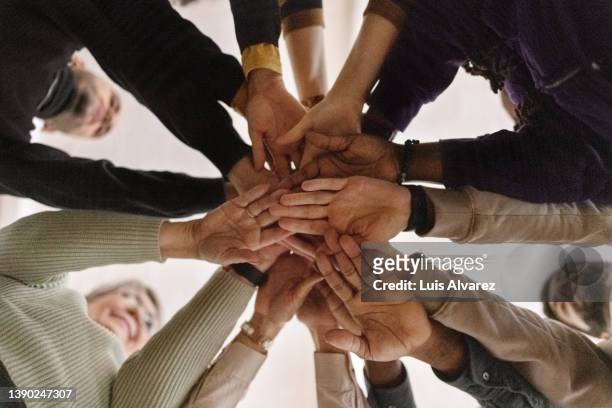people with hands put togehter during group therapy session - hand stack stock pictures, royalty-free photos & images