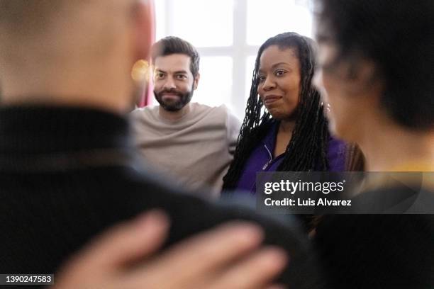 diverse group of people standing in a huddle during therapy session - gruppterapi bildbanksfoton och bilder