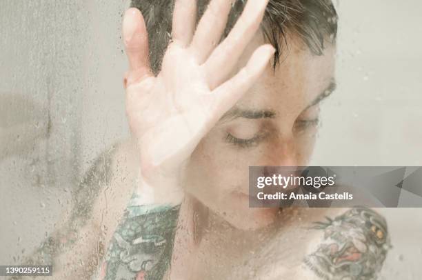 mujer tatuada disfrutando de una ducha. - ducha stock pictures, royalty-free photos & images