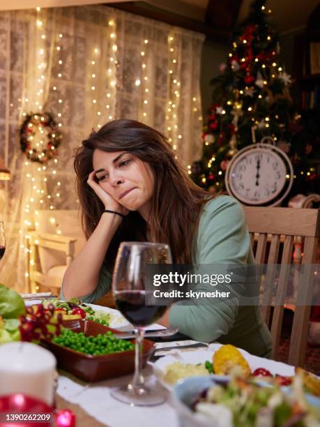 sad woman alone on new year's eve at dining table. - christmas dinner stock pictures, royalty-free photos & images