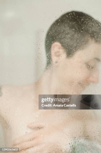 mujer en la ducha tras mampara salpicada de agua. - ducha stock-fotos und bilder