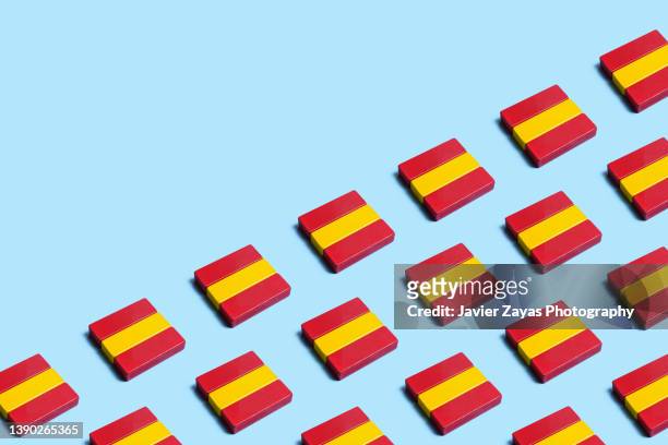 many spanish national flags formed by wooden toy blocks on blue background - royalty free stock pictures, royalty-free photos & images