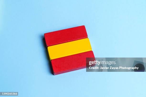 spanish national flag formed by wooden toy blocks on blue background - royalty free stock-fotos und bilder