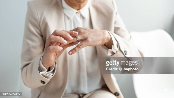 close up young woman taking off wedding ring - petition stock pictures, royalty-free photos & images