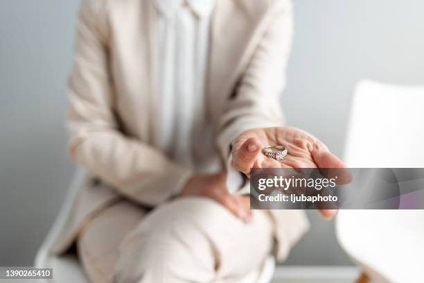 die braut hält den ehering in ihrer handfläche - alles aus einer hand stock-fotos und bilder