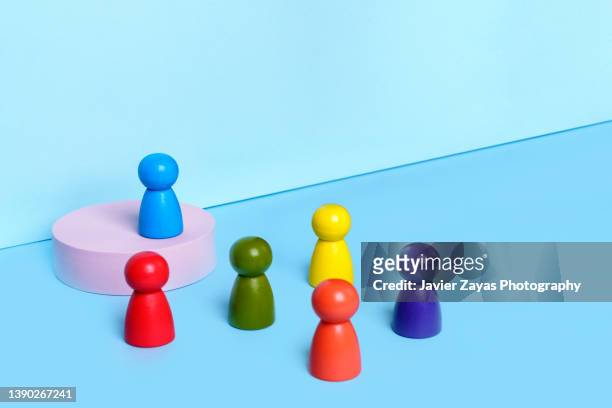 anthropomorphic multicolored wooden figures on blue - participant stock pictures, royalty-free photos & images