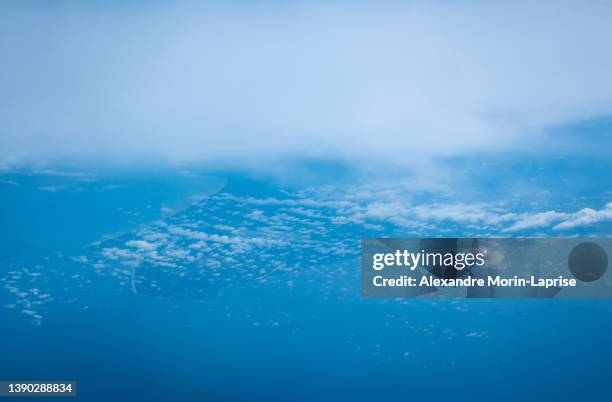 view of a colombian peninsula with clouds all around in a stunning blue cloudy sky high in the atmosphere - daylight saving time 2021 stock pictures, royalty-free photos & images