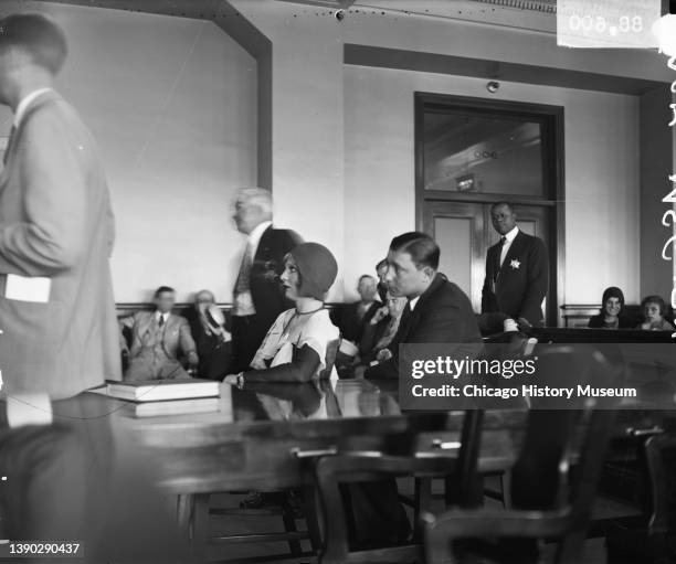 View of couple, Louise Rolfe and gangster Jack McGurn as they sit at a table in a courtroom, Chicago, Illinois, mid 1929. Rolfe provided an alibi for...