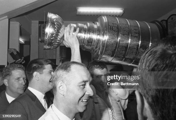 The Toronto Maple Leafs celebrate their Stanley Cup victory in the locker room with the cup.