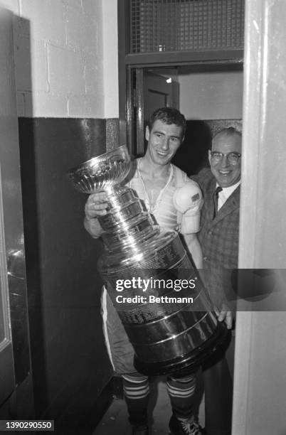 The Toronto Maple Leafs celebrate their Stanley Cup victory in the locker room with the cup.