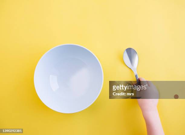 bowl and spoon - spoon in hand stock-fotos und bilder