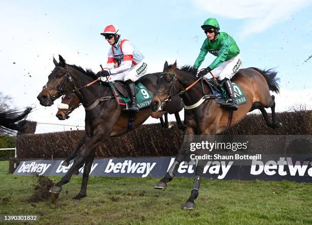 Harry Cobden on Saint Calvados and Daryl Jacob on Sceau Royal clear a fence in The Melling Chase race during Ladies' Day at Aintree Racecourse on...