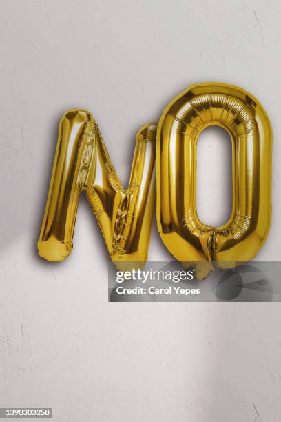 the word no   in golden foiled ballon - typographies stock-fotos und bilder