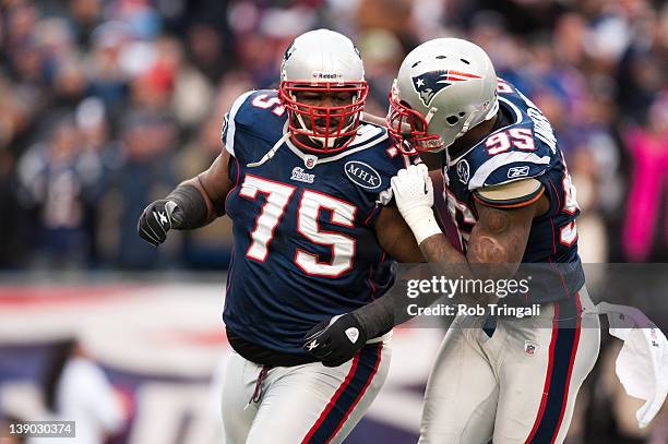 Defensive tackle Vince Wilfork and teammate defensive end Mark Anderson of the New England Patriots talk during the AFC Championship Game against the...