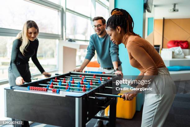 coworkers playing foosball - table football stock pictures, royalty-free photos & images