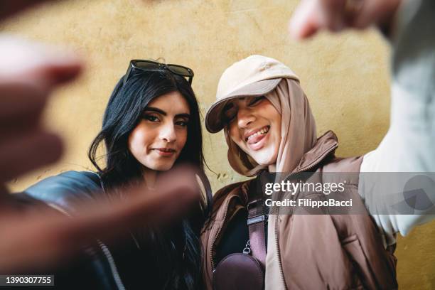 two young adult girls are making funny gestures to the camera - moroccan girls bildbanksfoton och bilder