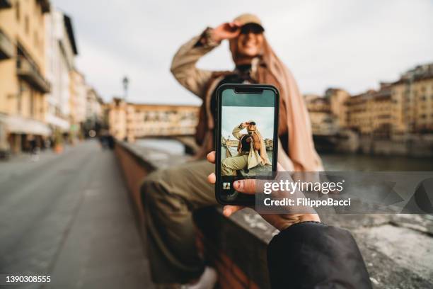 una joven adulta está tomando una foto a sus amigos - mensaje de móvil fotografías e imágenes de stock