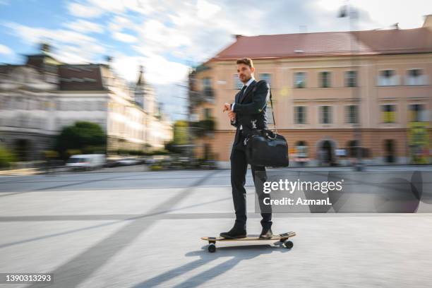 junger gutaussehender geschäftsmann auf longboard - longboard skating stock-fotos und bilder