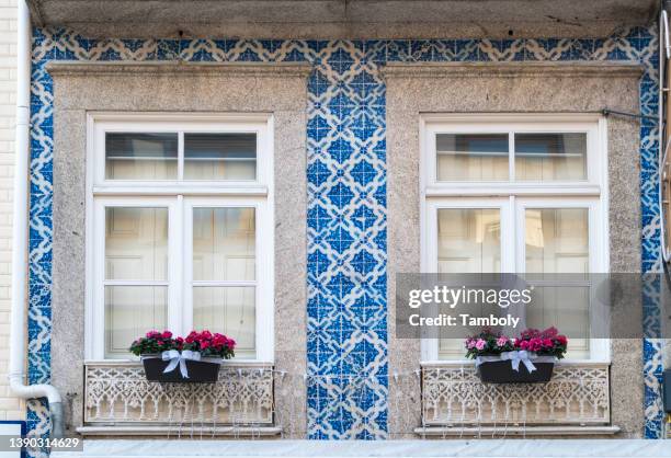 portugal, porto, apartment building with flowers on windows and azulejos - azulejos foto e immagini stock