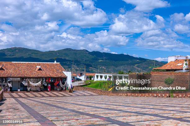 guatavita, colombia: looking down a sloping town square in the andes town. souvenir shops. background: andes mountains - cundinamarca stock pictures, royalty-free photos & images