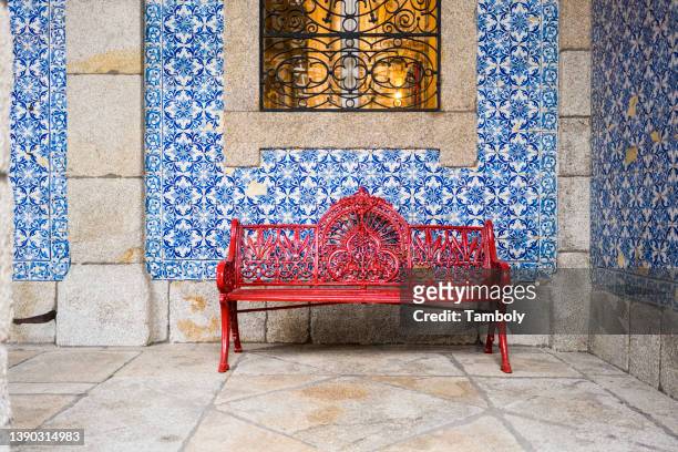 portugal, porto, red bench in front of wall covered with azulejos - azulejos foto e immagini stock