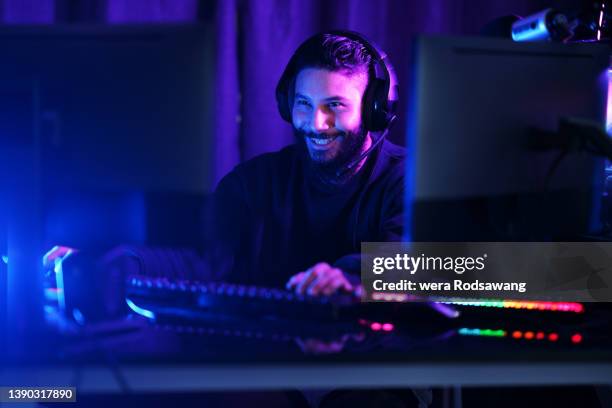 cheerful gamer guy playing online games for relaxation - joueur de jeux informatiques photos et images de collection