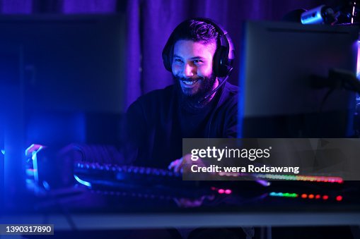 Cheerful gamer guy playing online games for relaxation Cheerful gamer guy playing online games for relaxation