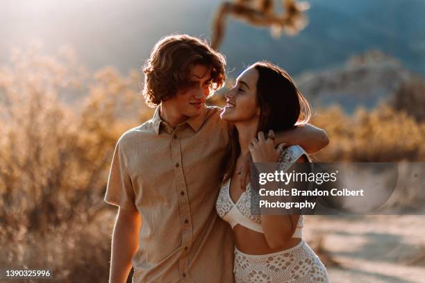 young couple enjoying a romantic walk in the park - enamorarse fotografías e imágenes de stock
