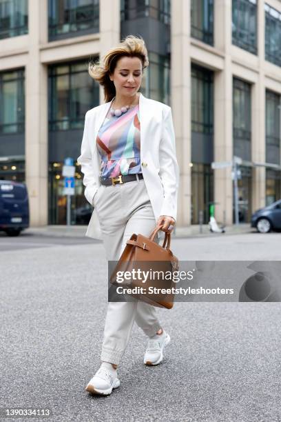 German TV host Bettina Cramer wearing a white blazer by Vero Moda, a multicolored blouse by Vero Moda, light grey pants by Object, white sneaker by...