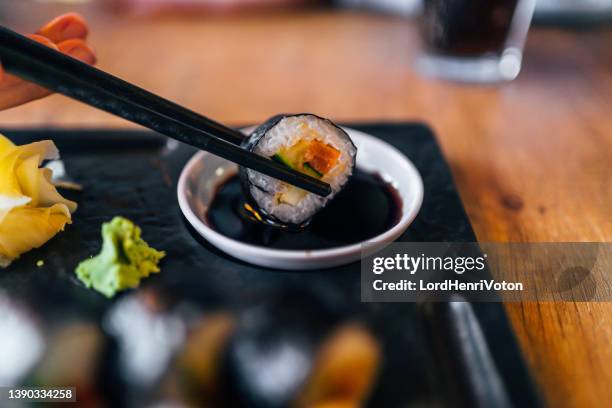 palillo con rollo de sushi y salsa de soja - rollo de salmón fotografías e imágenes de stock
