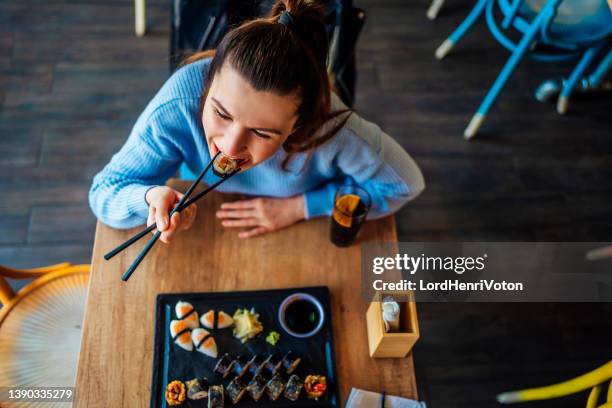 essen von sushi-rollen im japanischen restaurant - eating sushi stock-fotos und bilder
