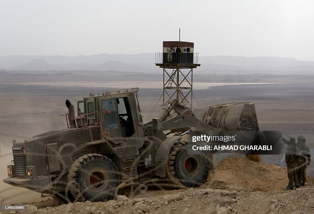 Egyptian border guards observe from a wa