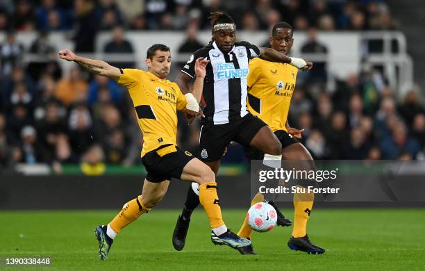 Allan Saint-Maximin of Newcastle United is challenged by Jonny Otto and Willy Boly of Wolverhampton Wanderers during the Premier League match between...