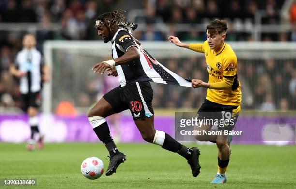 Allan Saint-Maximin of Newcastle United is challenged by Luke Cundle of Wolverhampton Wanderers during the Premier League match between Newcastle...
