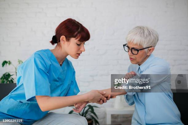 female medical professional examining a senior patient - patients brothers 個照片及圖片檔