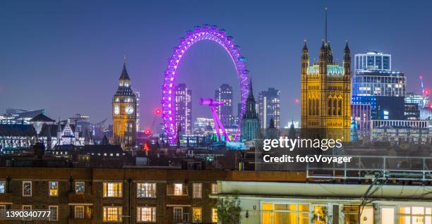 london landmarks big ben illuminated over rooftops at night panorama - big ben london eye dusk stockfoto's en -beelden