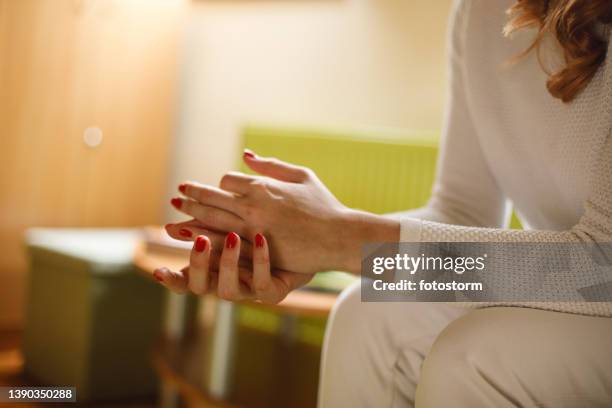 young woman fidgeting her arms while struggling with anxiety and negative emotions - knuckles stock pictures, royalty-free photos & images