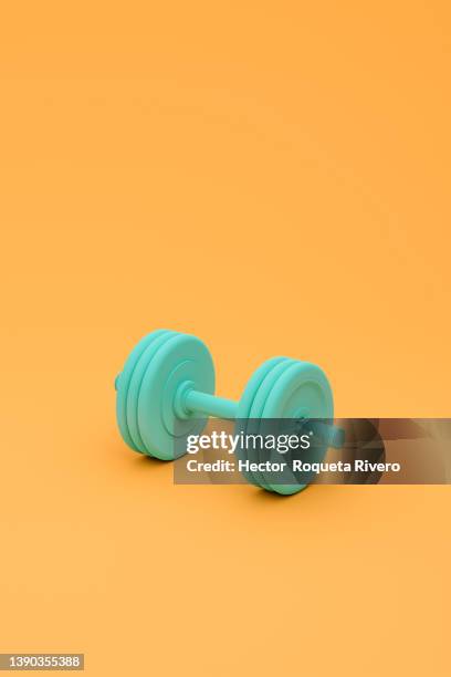 sport lifestyle concept with one green dumbbells on orange background.3d render - poids photos et images de collection