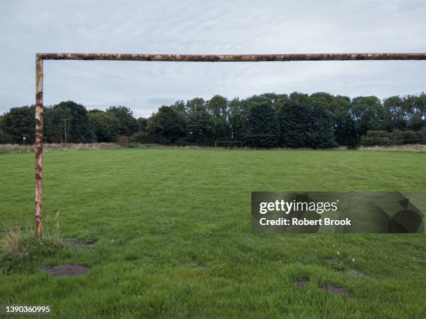 close-up of rusty goal post in field and another in the distance - local soccer field stock pictures, royalty-free photos & images