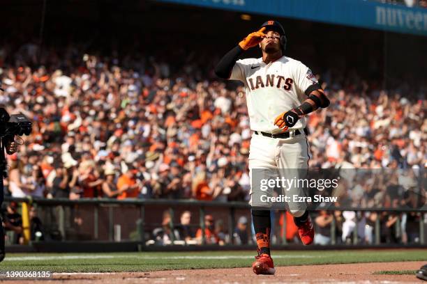 Thairo Estrada of the San Francisco Giants points to the sky as he crosses home plate after he hit a home run in the ninth inning to tie their game...