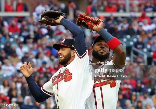 Dansby Swanson of the Atlanta Braves catches a fly ball by Joey Votto of the Cincinnati Reds as he avoids a near collision with Marcell Ozuna to lead...