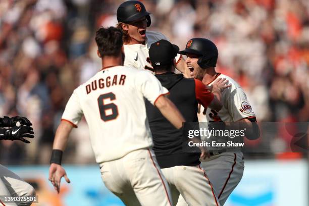 Austin Slater of the San Francisco Giants is congratulated by teammates after he hit a single that scored Darin Ruf of the San Francisco Giants in...