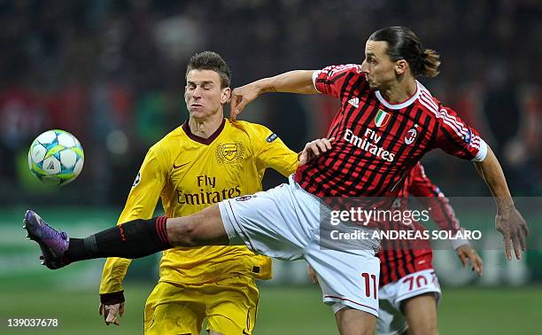 Milan's Swedish forward Zlatan Ibrahimovic fights for the ball against Arsenal's French player Laurent Koscielny during the UEFA Champions League...